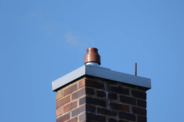 Red brick chimney against a blue sky.